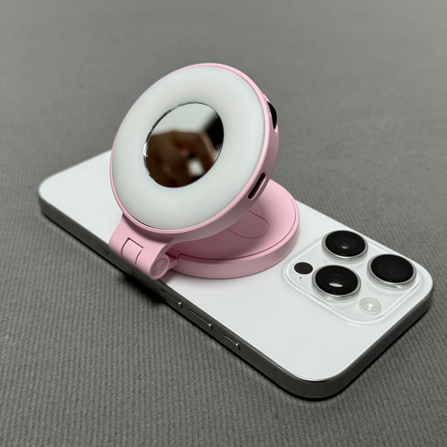 Pink phone ring holder on a smartphone with a gray background